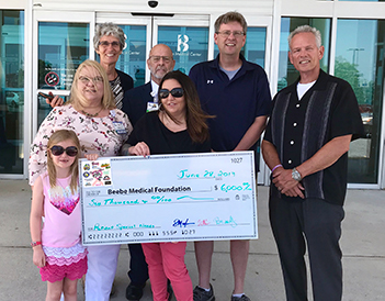 Shown during the check presentation (left to right) are Cast For A Cure organizers Brandy Timmons, with daughter Brooke, Clark Evans, and Scott Mayhugh present Beebe Medical Foundation with proceeds from the annual surf-fishing tournament to Beebe Heatlhc